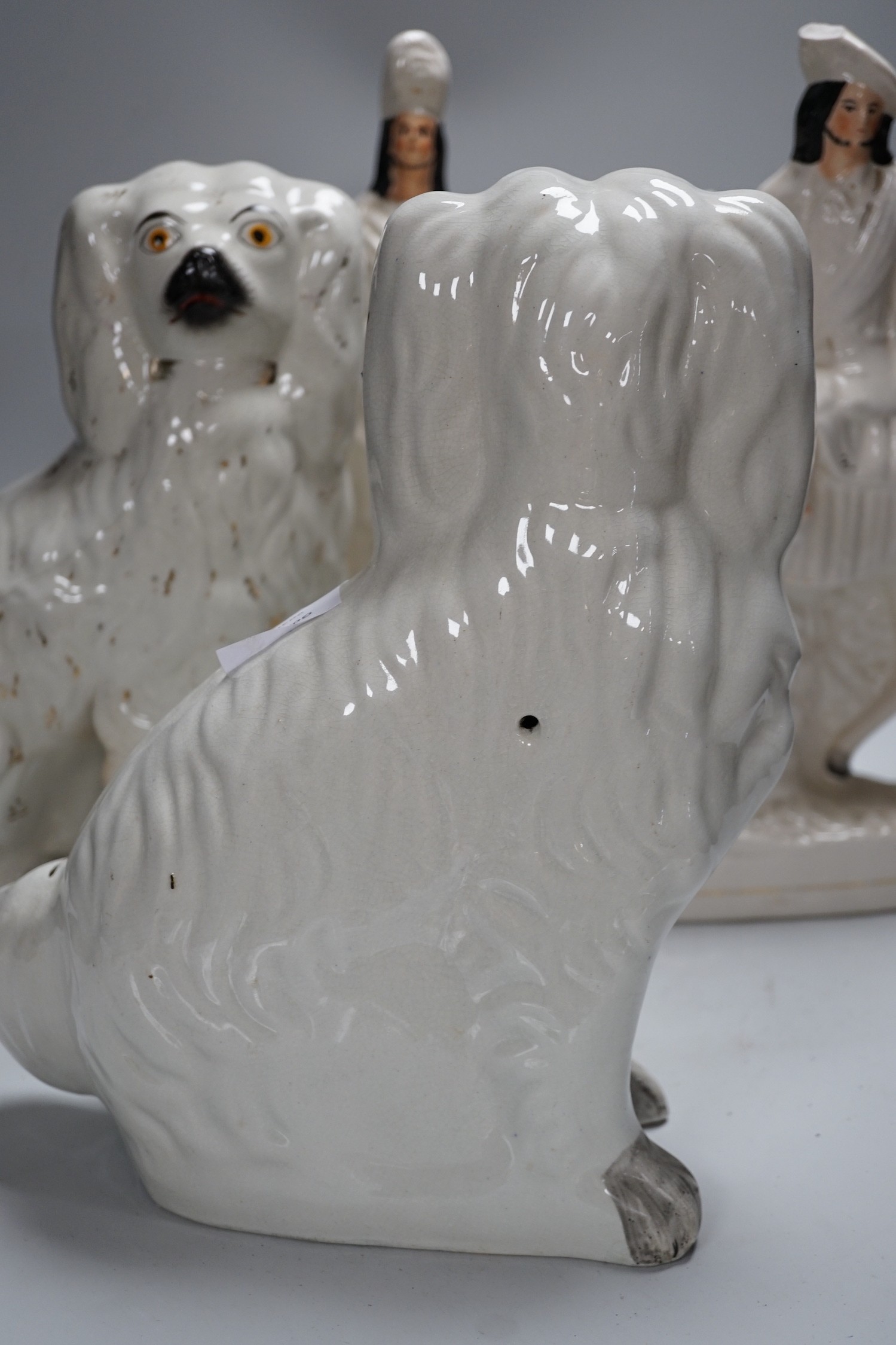 A pair of Staffordshire pottery spaniels, 30cm high, and a pair of equestrian groups, 19th century